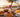 Frühstück mit Croissant, Pancakes, Yoghurt-Bowl und Cappuccino auf einer Holzterrasse direkt an der Promenade der Playa de Palma bei Sonnenaufgang – Frühstück Playa de Palma 2026